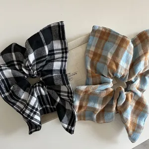 Detail of vintage oversized checkered bow scrunchie with soft fabric texture and ribbon