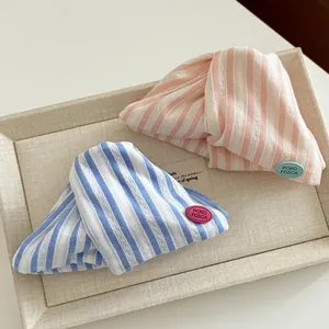 Detailed close-up of striped fabric shark hair clips with lace trim and logo patch