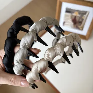 Détail d'un serre-tête en satin tissé avec peigne large en noir et beige