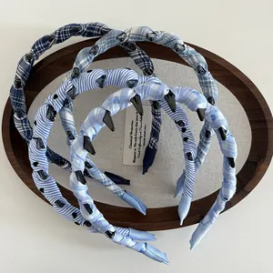 Detailed set of blue plaid and striped fabric headbands with anti-slip teeth in a tray