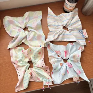Close-up of four floral bow scrunchies with beads on a warm wooden background