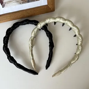 Détail de serre-têtes en satin avec dents antidérapantes en noir et couleur champagne