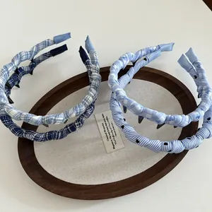 Detail of blue plaid and striped fabric headbands with non-slip teeth in a tray