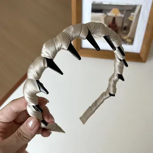 Détail d'un serre-tête en satin beige avec dents de peigne antidérapantes noires et tissage