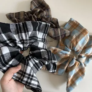 Three vintage plaid scrunchies in black, brown, and blue patterns on white background