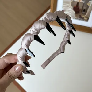 Détail du serre-tête en satin rose champagne avec dents de peigne pour un maintien parfait