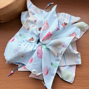 Detail of light blue satin scrunchie with bow tie and printed motivational text on wood background