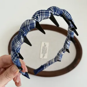 Detail of blue and white checkered headband featuring inner black plastic teeth for grip