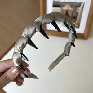 Détail macro du serre-tête en satin montrant les dents antidérapantes et le tissage