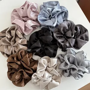 Flat lay of high-quality satin scrunchies in eight colors including silk-like pastel tones