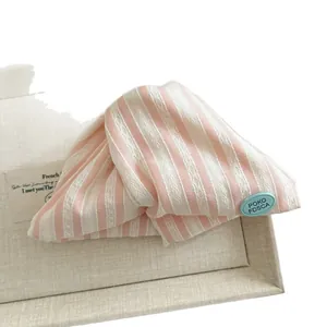 Pink and white striped fabric shark hair claw clip with light blue brand tag for women