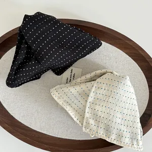 Detailed view of black and white polka dot fabric hair clips on a wooden tray