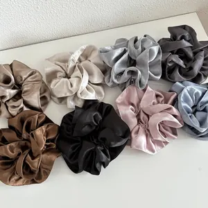 Flat lay of colorful large pearl satin scrunchies in various elegant shades