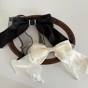 Elegant satin and organza bow hair clips with pearl drops in black and beige colors