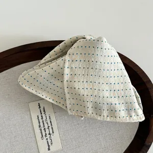 Close-up of cream polka dot fabric hair clip with detailed cotton-linen texture