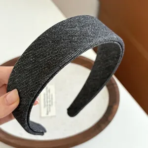 Macro view of dark denim fabric headband with subtle shimmer and thick padded edges