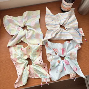 Set of four sweet bow scrunchies with stripe and bear prints on wooden table