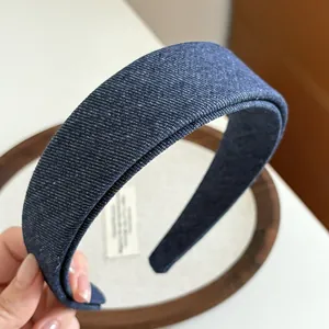 Macro detail of dark blue denim textured wide headband with premium fabric finish