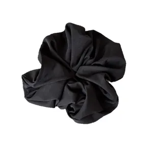 Minimalist black fabric scrunchie with soft glossy finish for elegant ponytails