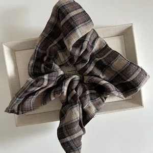 Vintage oversized brown and beige plaid scrunchie in a textured fabric on a display tray