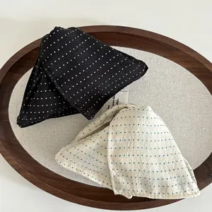 French style polka dot fabric triangle hair clips in black and white shown in a wooden tray
