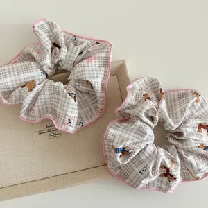 Detalle de coleteros a cuadros con estampados de perros lindos y bordes rosas ondulados
