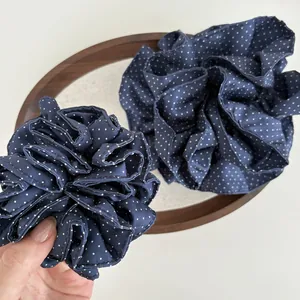 Dettaglio di elastici per capelli a pois blu scuro con trama in tessuto morbido