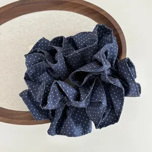 Vista ravvicinata di un grande elastico blu navy a pois bianchi su vassoio di legno