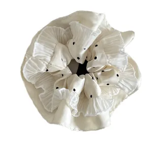Polka dot oversized scrunchie with layered ruffle edges in creamy white satin fabric