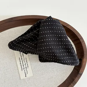 French style black and white polka dot fabric hair claw clip on a rustic wooden tray