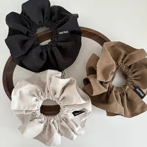 Detailed view of three-piece matte cotton scrunchie set in black, coffee, and beige colors