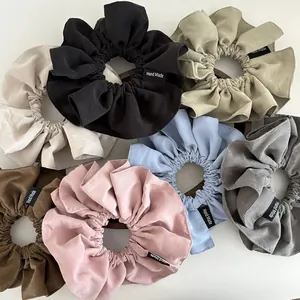 Set of matte chiffon oversized scrunchies in neutral colors with Hand Made label