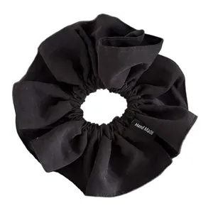 Black oversized fabric scrunchie with minimalist Hand Made label for ponytails
