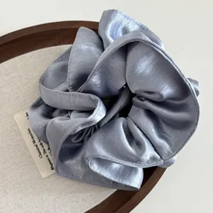 Eleganter hellblauer Perlen-Satin-Haargummi aus hochwertigem Seidenstoff in einem Holztablett