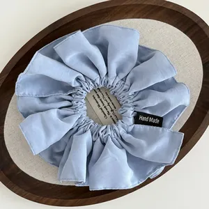 Light blue handmade satin scrunchie with delicate pleats and hand made label