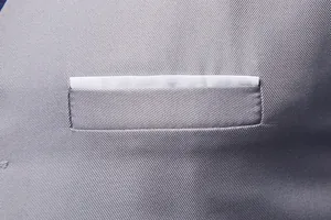 Detail of grey men's waistcoat with twill texture and white faux pocket square trim