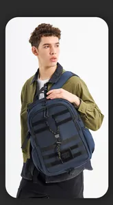 Detail eines navyblauen taktischen Rucksacks mit MOLLE-System und gelben Gummizügen