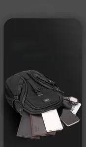 Detail view of black crossbody chest bag showing organized storage for gadgets and wallet