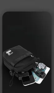 Detail of multi-layer black nylon shoulder bag showing storage for phone and accessories