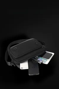 Macro shot showing high capacity of black crossbody bag with gadgets and multiple pockets