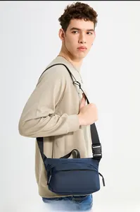 Close-up of durable navy nylon crossbody bag with adjustable wide strap and plastic buckle