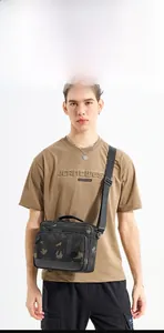 Detail of men's crossbody bag featuring dark camouflage pattern and durable nylon material