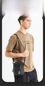 Vertical shot of a black minimalist men's crossbody bag on model for daily lifestyle use