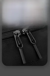 Détail des fermetures éclair doubles avec tirettes à nœuds sur un sac à bandoulière noir