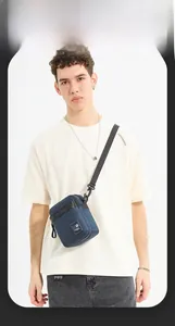 Detail of blue nylon crossbody bag featuring adjustable strap and brand logo patch