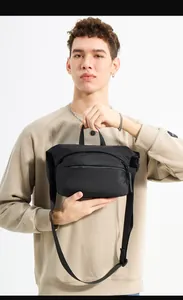 Close-up of WePower black nylon sling bag showing durable top handle and front zipper pocket