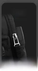 Detail of smooth silver metal zipper with black woven puller on high density nylon bag