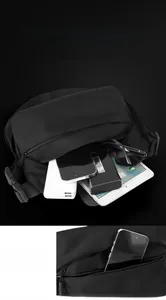 Detail showing the large main compartment and front zipper pocket of the black crossbody bag