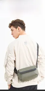Detail of army green crossbody bag with WE POWER logo and adjustable strap on a model