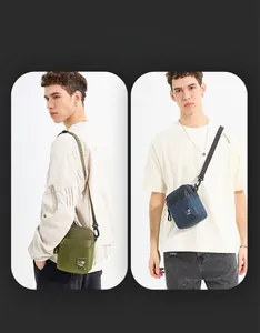 Close-up of olive green and navy blue nylon shoulder bags with adjustable straps